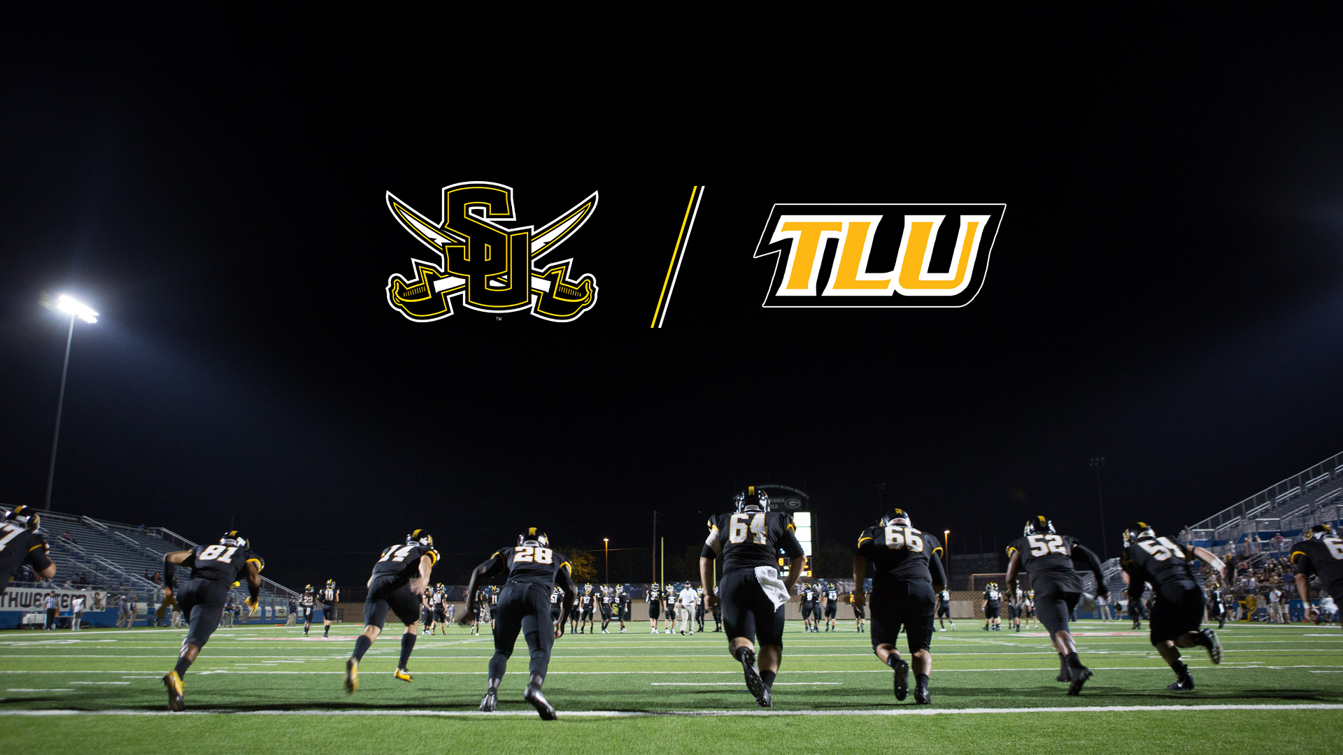 Southwestern University football team, wearing their black uniforms, run out on the field for a night game. Camera angle is behind them and low. Above is the logo for Southwestern and Texas Lutheran side-by-side. 