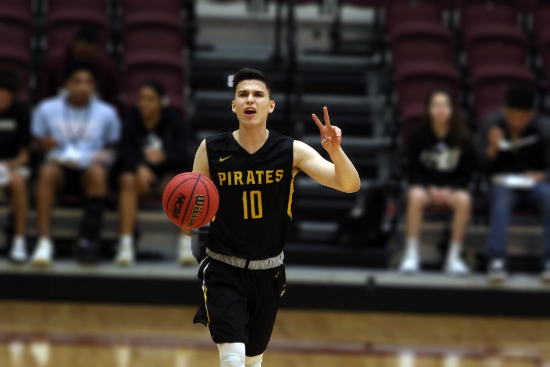 Southwestern University Pirates guard Joel Martinez extends two fingers to call out a play as he brings the ball up the court. 